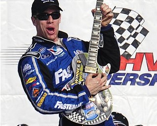 Carl Edwards celebrates with his  guitar trophy after winning the NASCAR Nationwide Series Nashville 300 auto race on Saturday, April 23, 2011, in Lebanon, Tenn. 