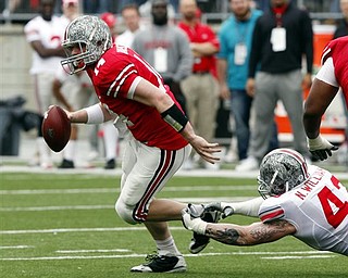Ohio State quarterback Joe Bauserman (14) breaks a tackle by defensive lineman Nathan Williams (43)during an NCAA college football Spring Game Saturday, April 23, 2011, in Columbus, Ohio. 