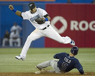 Toronto Blue Jays shortstop Yunel Escobar, top, forces out Tampa Bay Rays left fielder Sam Fuld, bottom on a single hit by Rays DH Johnny Damon, not shown during seveth inning AL Baseball action in Toronto on Saturday, April 23, 2011.