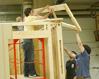 ROBERT K. YOSAY | THE VINDICATOR..Taking on the task of completely building a concession stand from design to ordering supplies then building the stand for the High School Baseball field  students in Mr. Glenn Sivak's  work class - from the bottom in black Dustin Ronci (sr) Dominic DiCioccio (sr) - on top is  Tyler Mobley (jr) (yellow) and  Tom Haus (jr) (gray)  - as they put the first of the roof trusses in place -..-30-