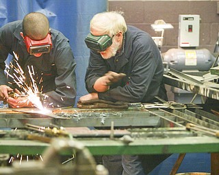 ROBERT K. YOSAY | THE VINDICATOR..Cutting a piece of metal  Tony Dundee a freshman - gets a hand from instructor Mr Bob Day . Students in addition to learning all facets of welding and cutting and working with metal they must also start and finish a metal project - ..-30-