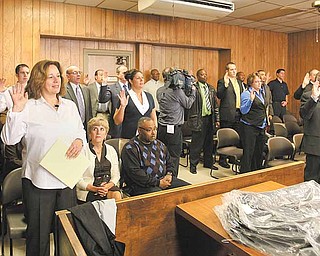 Youngstown Municipal Court Judges Elizabeth Kobly, Robert A. Douglas Jr. and Robert Milich (not pictured) swear in 30 part-time officers Monday to act as the security force in municipal court under the direction of city police.