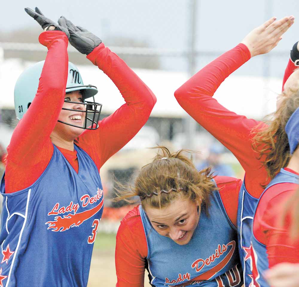 Western Reserve’s Sissy Stubbs, left, gets high fives from teammates after hitting a home run during Tuesday’s Inter Tri-County League softball game against Jackson-Milton. Western Reserve’s Rachael Obradovich, center, avoids the celebration.
