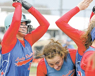 Western Reserve’s Sissy Stubbs, left, gets high fives from teammates after hitting a home run during Tuesday’s Inter Tri-County League softball game against Jackson-Milton. Western Reserve’s Rachael Obradovich, center, avoids the celebration.
