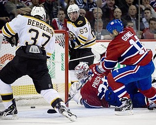 Montreal Canadiens' goaltender Carey Price, bottom, is scored on by Boston Bruins' Patrice Bergeron (37) as Canadiens' Scott Gomez (11) and Bruins' Brad Marchand (63) look for a rebound during second period of Game 4 of a first-round NHL Stanley Cup playoff series in Montreal, Thursday, April 21, 2011.