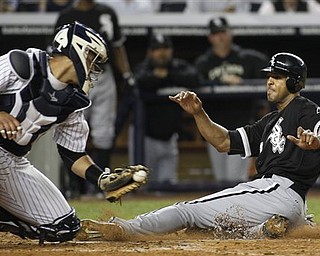 New York Yankees catcher Gustavo Molina looks to make the tag as Chicago White Sox's Alex Rios scores in the fifth inning of a baseball game at Yankee Stadium on Tuesday, April 26, 2011, in New York.