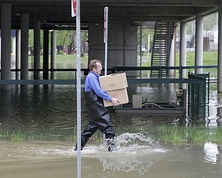 Facilities worker Mike Albrecht walks through water from the rising Ohio River as he carries supplies from Riverview East Academy, Monday, April 25, 2011, in Cincinnati, Ohio. The grade school is built on stilts because of possible flooding and students were moved to another school until the river goes down.