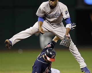 Kansas City Royals shortstop Alcides Escobar leaps over Cleveland Indians baserunner Shin-Soo Choo after forcing him out at second and then throwing to first on a ground ball by Indians' batter Carlos Santana in the fifth inning of a baseball game in Cleveland on Tuesday, April 26, 2011.  Santana was safe at first on the play.  