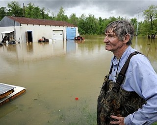 Leon Gentry looks out over flood waters from Canoe Creek that surround his garage on Alma Avenue, after he spent the morning working to secure what he could from the rising water in Henderson, Ky., Monday, April 25, 2011. Heavy rain and severe storms are expected to continue throughout the week after most of the state received up to 4 inches of rain during the weekend. Rainfall totals for the past week range from 10 inches to 15 inches statewide, causing flooded rivers, streams and tributaries. 