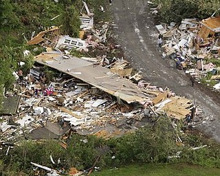 People walk on a road in Vilonia, Ark., Tuesday, April 26, 2011, after a tornado hit the area late Monday. The storm system killed at least seven people, including three who drowned in floods in northwest Arkansas.