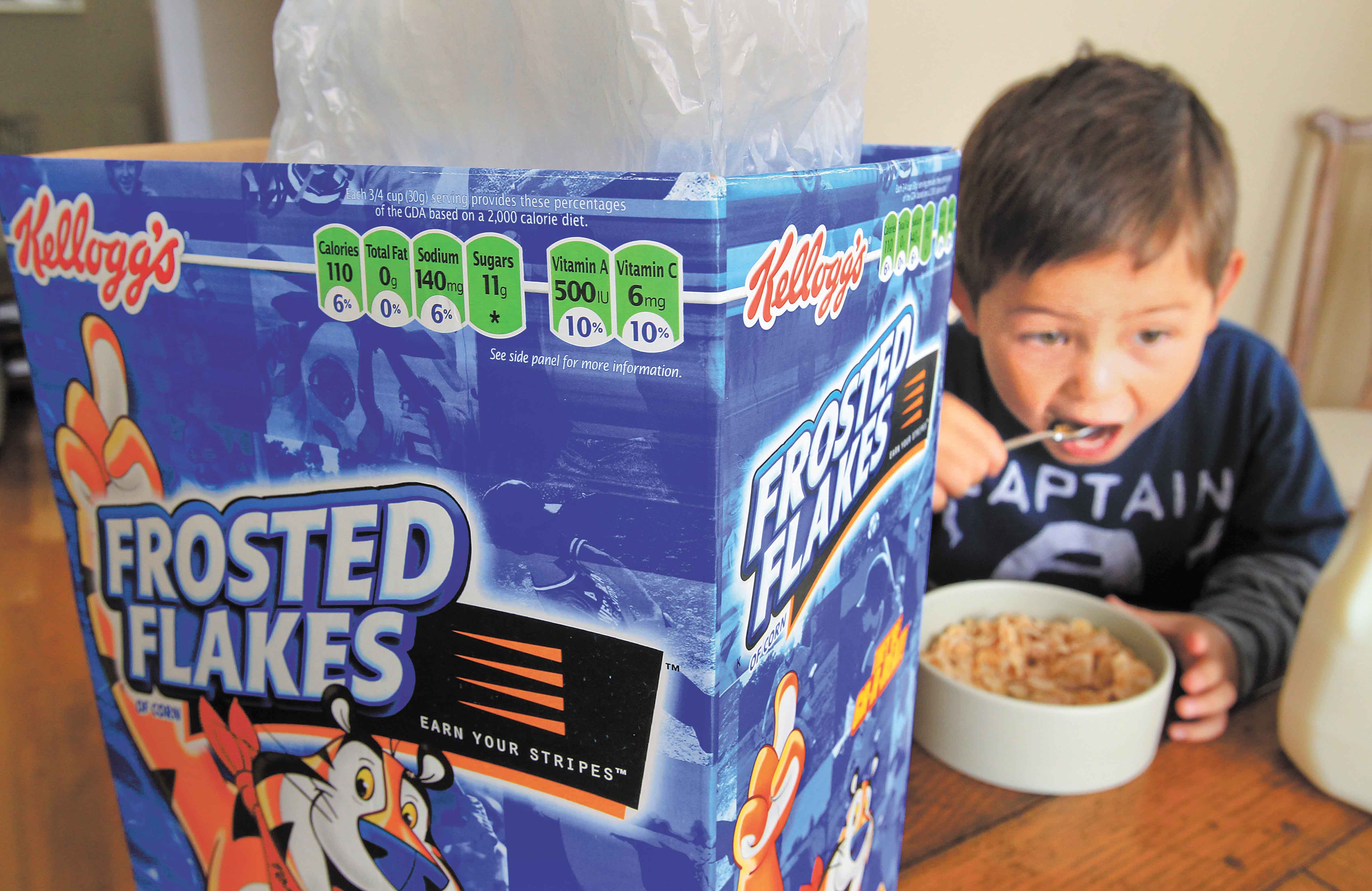 Nathaniel Donaker, 4, eats Kellogg’s Frosted Flakes cereal at his home in Palo Alto, Calif., on Thursday. Commercials promoting sugary breakfast cereals could be put on a strict diet under government guidelines.