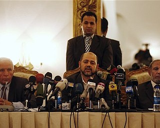 Chief Fatah negotiator for the reconciliation talks Azzam al-Ahmed, left, sits next to Hamas leaders Moussa Abu Marzoug, center, and Mahmoud Al Zahar, right, during a news conference in Cairo, Egypt, Wednesday, April 27, 2011. Palestinians have reached initial agreement on reuniting their rival governments in the West Bank and Gaza, officials from both sides said Wednesday, a step that would remove a main obstacle in the way of peace efforts with Israel. (AP Photo/Khalil Hamra)