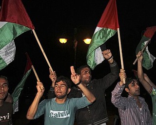 Palestinians wave flags and chant slogans in support of a reconciliation between the rival Fatah and Hamas movements, in Gaza City, Wednesday, April 27, 2011. Palestinians have reached initial agreement on reuniting their rival governments in the West Bank and Gaza, officials from both sides said Wednesday, a step that would remove a main obstacle in the way of peace efforts with Israel. (AP Photo/Adel Hana)