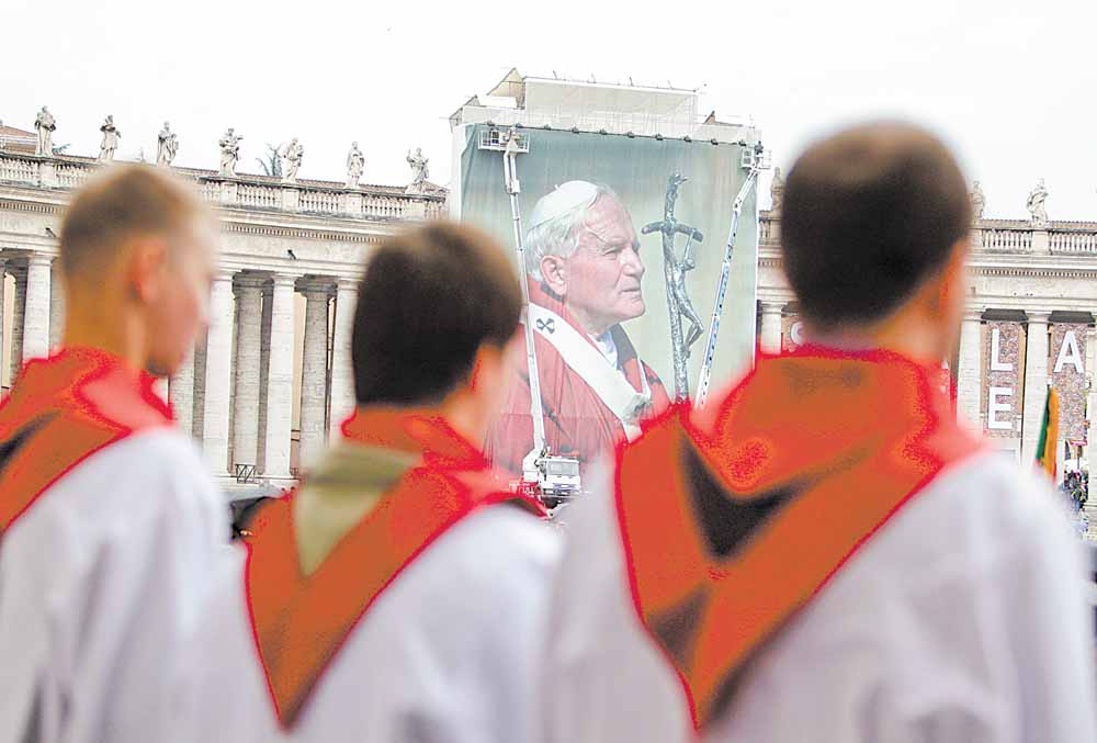 A Polish choir sings in front of a giant photograph of late Pope John Paul II, set up in St. Peter's Square, at the Vatican, Saturday, April 30, 2011. On Sunday, Pope Benedict XVI will beatify John Paul II in St. Peter's Square at the Vatican. 