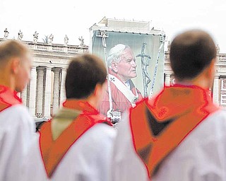 A Polish choir sings in front of a giant photograph of late Pope John Paul II, set up in St. Peter's Square, at the Vatican, Saturday, April 30, 2011. On Sunday, Pope Benedict XVI will beatify John Paul II in St. Peter's Square at the Vatican.