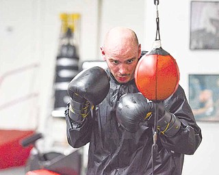 Former middleweight boxing champion Kelly “The Ghost” Pavlik concentrates on a double-ended punching bag during a workout at the Southside Boxing Club in preparation for his upcoming fight next weekend.