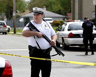 A Columbus police officer stands guard near the scene of a shooting in Columbus, Ohio on Saturday, April 30, 2011. Authorities have identified the man killed in a shootout with police that left four people injured, including three officers. Columbus police identified him as 27-year-old Randle Lee Roberts II. They didn't say where he lives. They learned after the shootout Saturday that Roberts might be a suspect in a quadruple homicide about 90 miles south in Adams County at a house along a rural state highway near the village of West Union. An Adams County dispatcher confirms the sheriff's office is investigating the four deaths but hasn't released details.