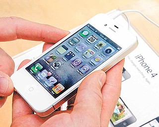 In this April 28, 2011 photo, a customer holds a white iPhone at the Apple store on New York's Upper West Side. People are turning over personal information to online retailers, social networks and others in growing numbers, even as concerns about privacy mount.