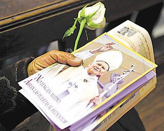 A woman holds a photograph of late Pope John Paul II during a Mass commemorating his beatification at the cathedral in La Paz, Bolivia, Sunday, May 1, 2011. Catholics worldwide celebrated the beatification of Polish-born Karol Wojtyla on Sunday, with the faithful jamming churches to pray and witnessing on TV screens the Vatican ceremony that brought him one step closer to possible sainthood.