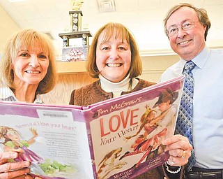 From left, Seaborn Elementary School library aide Marci Buchanan, Principal Cynthia Mulgrew and her husband, Edward Mulgrew, with a copy of Tim McGraw's book "Love Your Heart" in Mineral Ridge. The book features a character named Mrs. Mulgrew but was not based on the Seaborn principal.