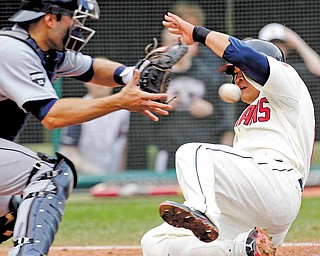 Cleveland Indians' Shin-Soo Choo, right, scores as Detroit Tigers catcher Alex Avila, left, waits for the ball in the eighth inning of a baseball game on Sunday, May 1, 2011, in Cleveland. Choo scored on a single by Orlando Cabrera. The Indians won 5-4.