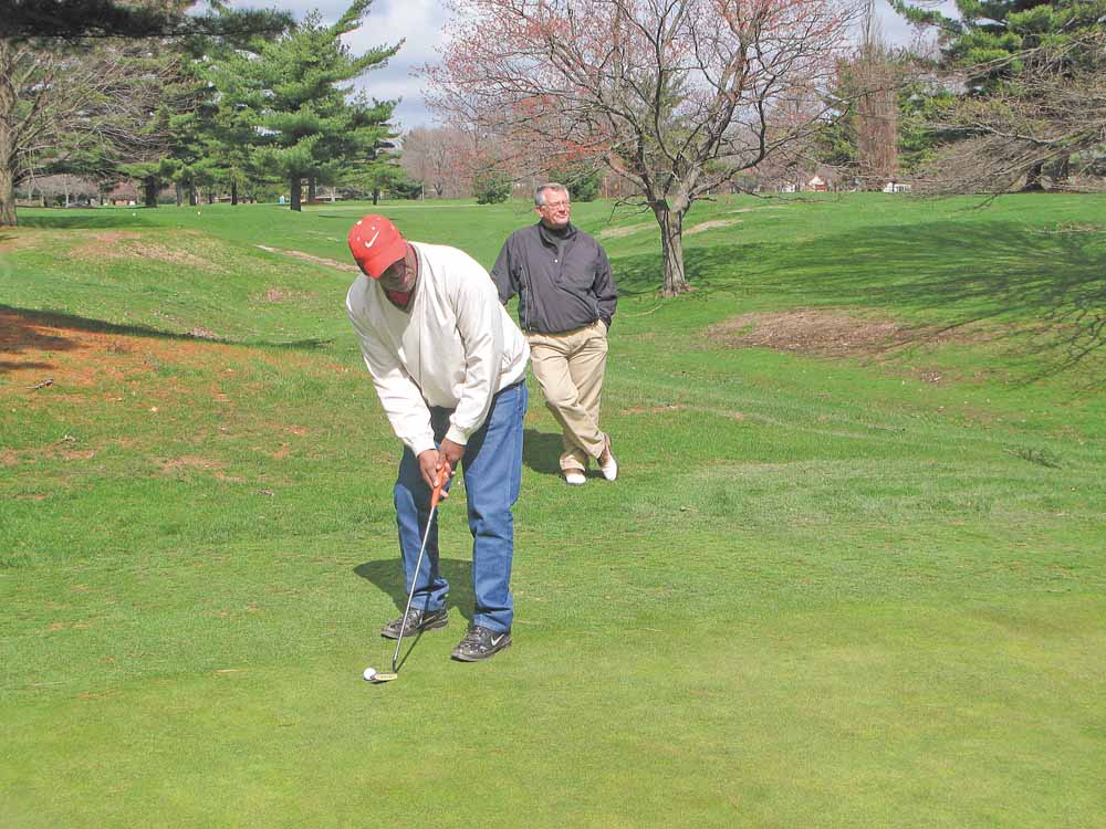 James Overton of Youngstown, under the watchful eye of PGA pro Dave Boos, prepares to take a shot on the No. 1 Par 4 Hole at the Henry Stambaugh Municipal Golf Course, where the 2011 Greatest Golf Holes of the Valley will tee off  today. The event, sponsored by The Vindicator and Farmers National Bank in partnership with eight area golf courses, again  showcases the best holes on area courses, but this time as determined by Valley golfers. 
