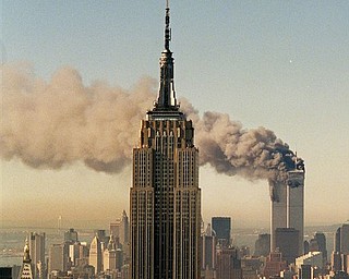 FILE - In this Sept. 11, 2001 file photo, the twin towers of the World Trade Center burn behind the Empire State Building in New York. Osama bin Laden, the glowering mastermind behind the Sept. 11, 2001, terror attacks that killed thousands of Americans, was slain in his luxury hideout in Pakistan early Monday, May 2, 2011 in a firefight with U.S. forces, ending a manhunt that spanned a frustrating decade.