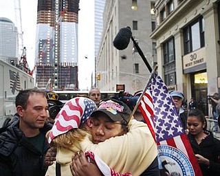 Dionne Layne, facing camera, hugs Mary Power as they react to the news of the death of Osama bin Laden, Monday, May 2, 2011 in New York. At left is the under construction 1 World Trade Center, also known as the Freedom Tower.