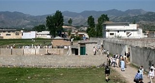 Local people and news media gather round the compound and house, seen on right, of Osama bin Laden as authorities eased the security and allowed people to approach the perimeter of the compound in Abbottabad, Pakistan, on Tuesday, May 3, 2011, after a U.S. military raid late Monday which ended with the death of the al-Qaida leader Osama bin Laden and others inside the compound. U.S. Navy SEALs swept through the massive compound Monday in pursuit of their target, bin Laden, and it is revealed Tuesday by White House counterterrorism adviser John Brennan that the U.S. already was scouring through items seized in the raid, said to include hard drives, DVD's, a pile of documents and other items.