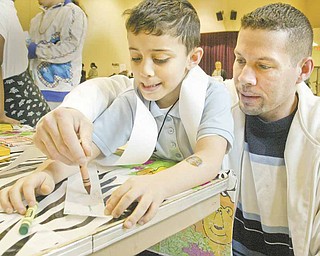 Curtis Megginson III and his son Curtis Megginson IV work on a coloring project during Family Night at Taft Elementary School on Youngstown’s South Side. The boy is a kindergarten student at Taft.