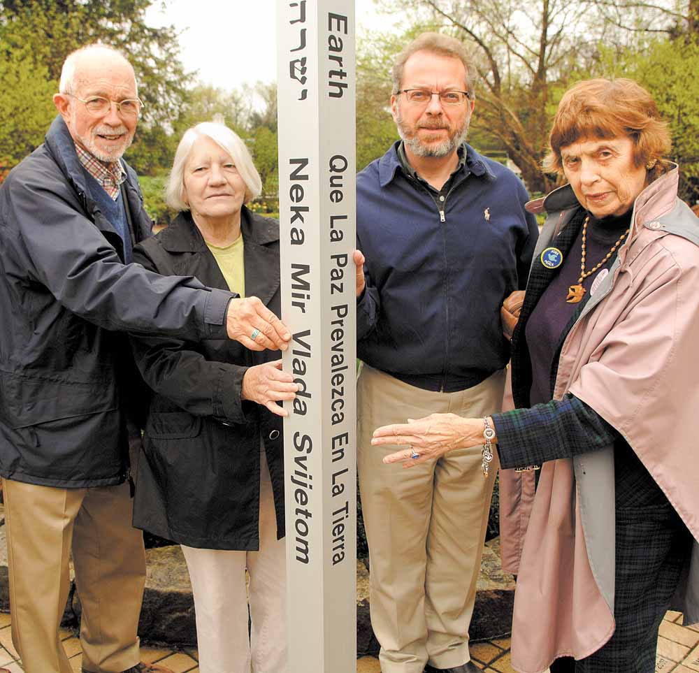Members of Seniors for Peace meet with Keith Kaiser, second from right, horticulture director at Mill Creek MetroParks, to admire the peace pole that will be installed and dedicated in a brief ceremony at 11 a.m. Friday in Fellows Riverside Gardens. Seniors for Peace members are, from left, the Rev. Jim Ray, Shirley Megown and Norma Coe Anderson. The message, “May Peace Prevail on Earth,” is in eight languages. 