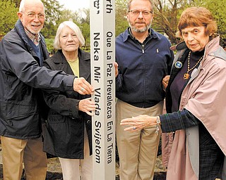 Members of Seniors for Peace meet with Keith Kaiser, second from right, horticulture director at Mill Creek MetroParks, to admire the peace pole that will be installed and dedicated in a brief ceremony at 11 a.m. Friday in Fellows Riverside Gardens. Seniors for Peace members are, from left, the Rev. Jim Ray, Shirley Megown and Norma Coe Anderson. The message, “May Peace Prevail on Earth,” is in eight languages.