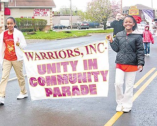 CeAnna Curtis, 9, left, and TaNia Simms, 10, lead a unity parade down Market Street on Youngstown’s South Side Saturday morning.