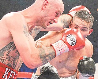 Kelly Pavlik, left, exchanges punches with Alfonso Lopez in the third round during a WBO World super bantamweight title bout, Saturday, May 7, 2011, in Las Vegas.