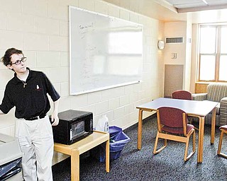 YSU engineering student Jarrett Scacchetti checks a light switch in Cafaro House. He is part of a group participating in the National Electrical Contractors Association Green Energy Challenge.