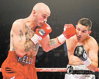 Kelly Pavlik, left, lands a punch against Alfonso Lopez in the first round during a WBO World super bantamweight title bout, Saturday, May 7, 2011, in Las Vegas.