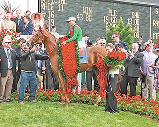 Youngstown businessman Bruce Zoldan (standing behind man holding Animal Kingdom) celebrates with the other owners of the Kentucky Derby winner at Churchill Downs. Behind Zoldan is NBC’s Bob Costas.