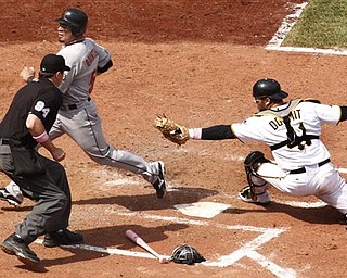 Pittsburgh Pirates catcher Ryan Doumit, right, cannot get the tag on Houston Astros' Humberto Quintero, upper left, with umpire Lance Barrett (94) making the call during the seventh inning of a baseball game in Pittsburgh, Sunday, May 8, 2011. Quintero scored from second on a bunt by Astros' Angel Sanchez and an error. The Pirates won 5-4.