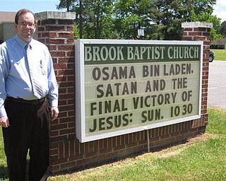 In this May 5, 2011 photo, Rev. David Howard poses by a marquee outside Brook Baptist Church in Virginia Beach, Va. Howard changed his sermon after a Navy SEAL team based in Virginia Beach killed Osama bin Laden.