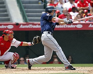 Cleveland Indians' Grady Sizemore hits a home run with Los Angeles Angels catcher Hank Conger looking on during the fifth inning of a baseball game in Anaheim, Calif., Sunday, May 8, 2011.