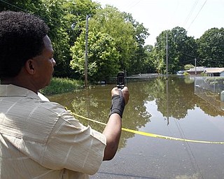 Cedric Briggs takes a photo with his phone in the Box Town neighborhood Sunday, May 8, 2011 in Memphis, Tenn. as flood waters continue to rise along the Mississippi River.