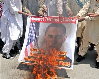 Activists of a local social group Muthahida Shehri Mahaz, burn a banner depicting U.S. President Barack Obama, during a rally to condemn the killing of al-Qaida leader Osama bin Laden, in Multan, Pakistan, Sunday, May 8, 2011. As U.S. investigators comb through a treasure trove of computer data and documents seized from Osama bin Laden's home, Pakistani officials face a more domestic task: What to do with three of the slain terrorist leader's wives and eight of his children.