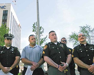 Local police and firefighters gathered in downtown Youngstown to honor officers killed in the line of duty. They are, from left, Youngstown Police Officer Sam Mosca; Christopher Weaver, Youngstown Professional Firefighters union; Sgt. T.J. Assion, Mahoning County Sheriff’s Department and president of Fraternal Order of Police Lodge 141; and Sgt. Salvatore Pascarella from the sheriff’s department. Monday’s event was part of National Police Memorial Week, but the gathering also focused attention on the new Ohio law that limits collective-bargaining rights of public employees like police officers and firefighters.