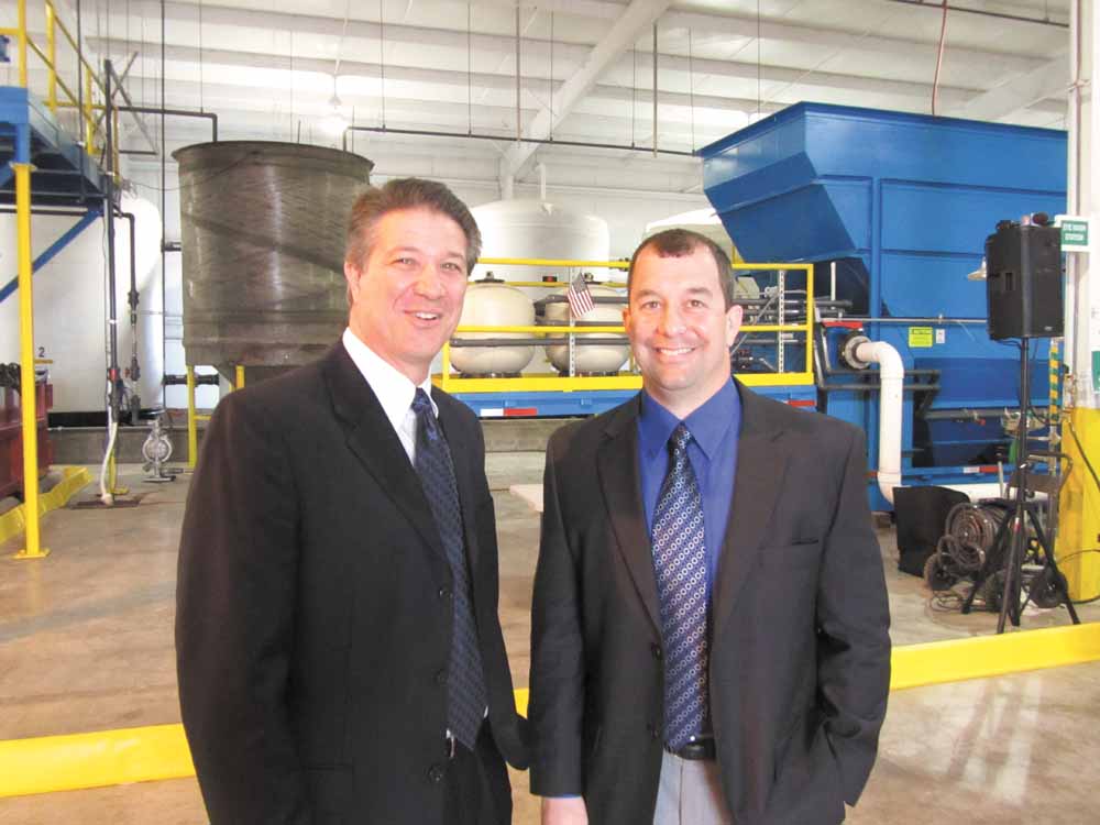 Tom Angelo, Warren water-pollution control director, left, stands with  Andrew Blocksom of Lisbon, owner of Patriot Water Treatment, inside Patriot’s water-treatment plant on Sferra Avenue Northwest in Warren Commerce Park. The company had a  ribbon cutting and showed how the plant removes salt, metals and solids from water coming from Marcellus-Shale  drilling operations. 