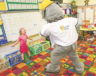 Scrappy, the mascot for the Mahoning Valley Scrappers minor-league baseball team, plays with kindergartner Jessica Hentzel who pulled his tail. The 23 students in Robin Speece’s class at Austintown’s Lloyd Elementary School earned a pizza party Wednesday with the mascot for reading 1,684 books since January.