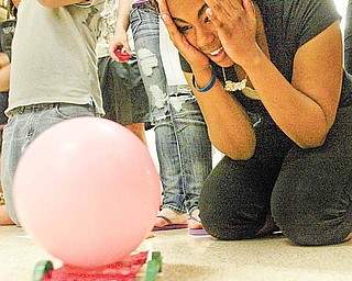 Paige Saunders, 15, a ninth-grader in Joe Slifka’s physical science class at Liberty High School, reacts to the performance of “Lola,” the nickname of the team’s balloon-powered race car, Wednesday. The goal of the project was for students to see the practical side of Newton’s laws of motion. Students designed and built cars powered by air in a balloon.