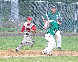 West Branch baseball co-coach Walt DeShields watches as Niles’ Michael Waton (3) runs down the Warriors’ Matt Edie (16) during a Division II sectional final baseball game Friday at Cene Park in Struthers. The Red Dragons downed the Warriors, 10-5, to set up a showdown with Canfield.