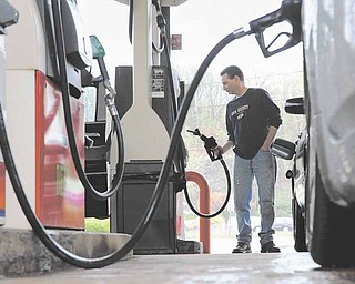 FILE- In this April 28, 2011 file photo, John Magel pumps gas at a station in Wethersfield, Conn. Consumers paid more for gas and food in April, lifting inflation to its highest level in two and a half years. But inflationary pressures have begun to ease in May 2011, and analysts say some prices could taper off by summer. (AP Photo/Jessica Hill, file)
