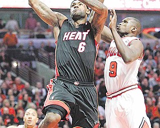 Miami Heat's LeBron James, left, drives to the basket past Chicago Bulls' Luol Deng during the first quarter in Game 1 of the NBA Eastern Conference Finals basketball series  Sunday, May 15, 2011 in Chicago. 