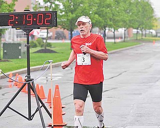 Dave White, 70, crosses the finish line as the oldest competitor at the  2011 Davis Family YMCA/ Steel Valley Tri Club Spring Distance Triathalon.